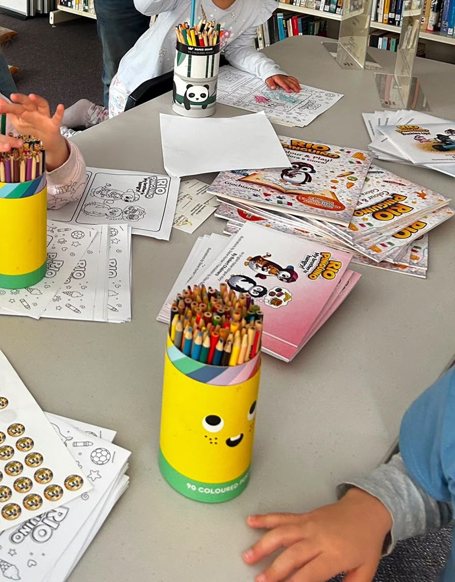 Kids colouring in Rio Pinguino activity sheets at the event